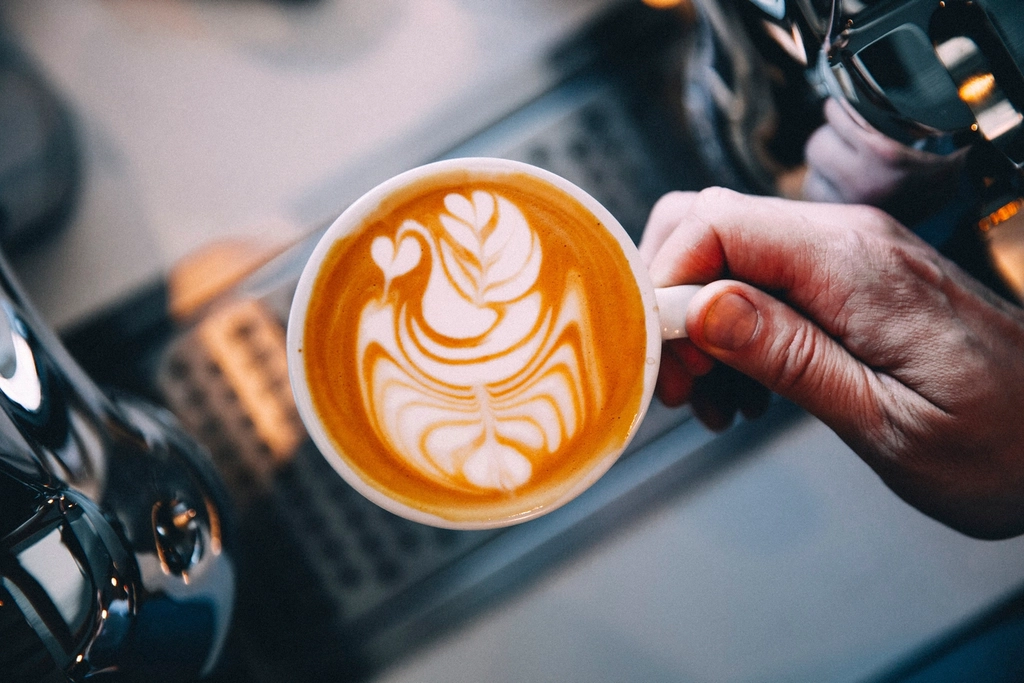 Café con leche y arte latte servido desde una cafetera superautomática
